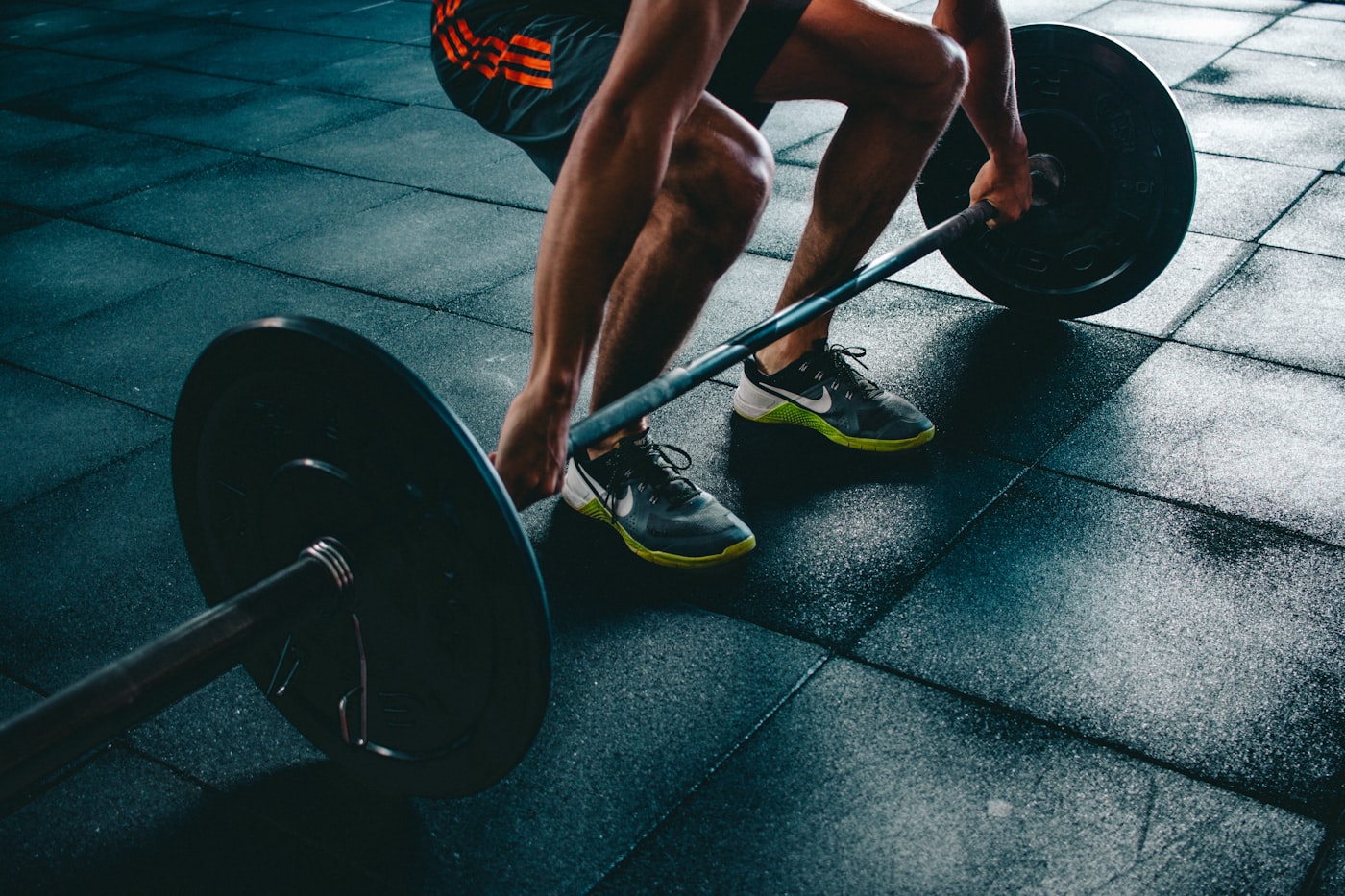 Athlete preparing to deadlift a barbell in a gym